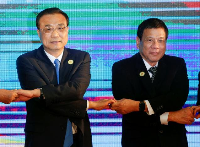 Tổng thống Philippines Rodrigo Duterte và Thủ tướng Trung Quốc Lý Khắc Cường bắt chéo tay trong Thưởng đỉnh ASEAN tại Lào 6/9/2016