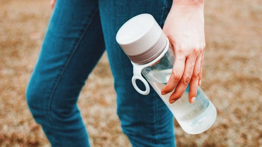 A person carrying an electrolyte drink.