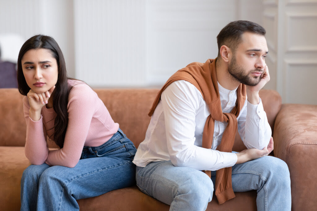 Casal sentado no sofá enquanto discute a decisão de casar