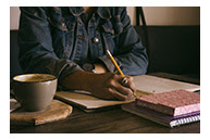 person writing at table