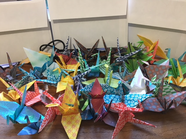 Picture of an asortment of paper cranes on a table.