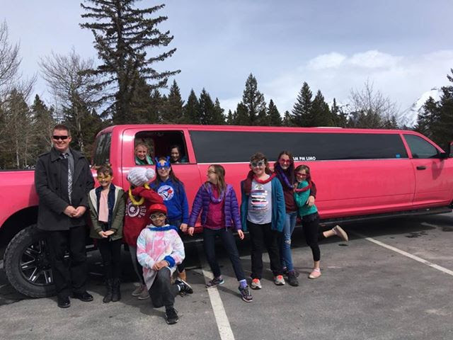 Kids celebrating birthday party in front of Pink Dodge Ram Limo