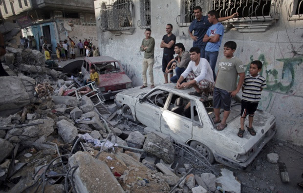 Palestinians look the damage of a destroyed house where five members of the Ghannam family were killed in an Israeli missile strike early morning in Rafah refugee camp, southern Gaza Strip.