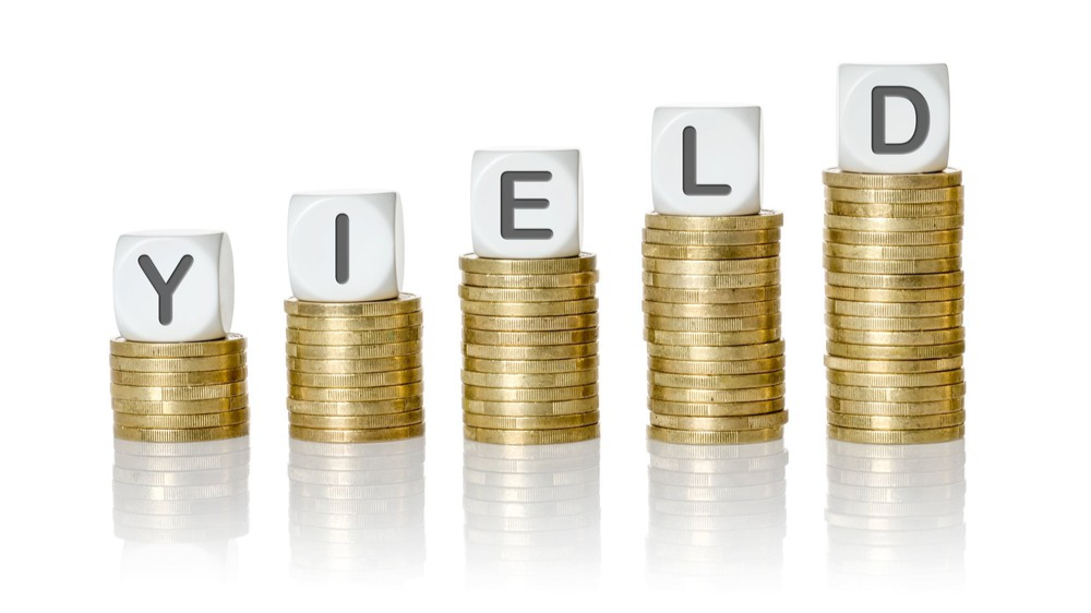Yield written on die across advancing stacks of coins Yield written on die across advancing stacks of coins