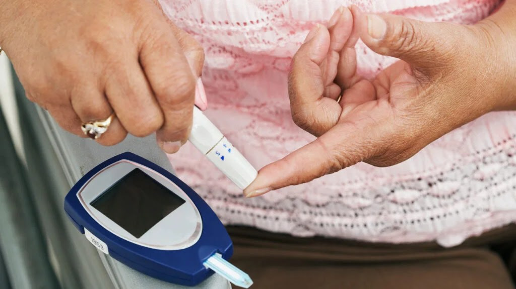 Woman measuring blood glucose level