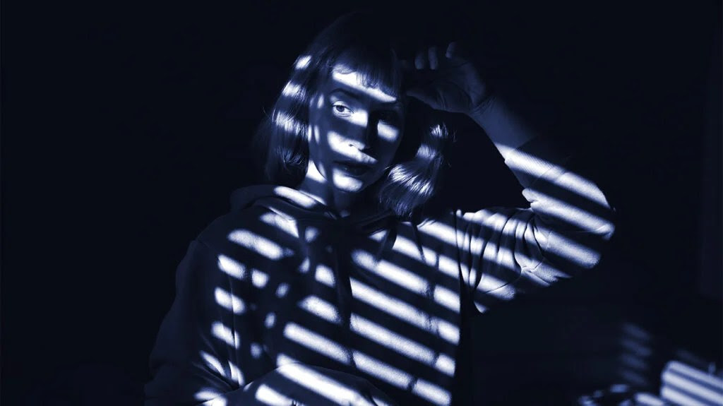 A black and white image of shadows on a woman's face.