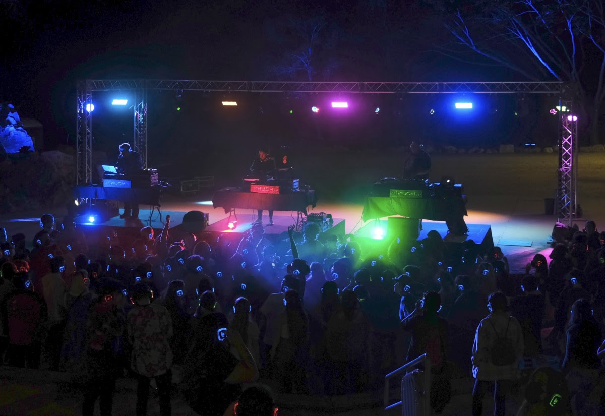 'Four DJs play music on stage while participants with lighted headphones dance after dark at the silent disco at the Quarry Amphitheater'