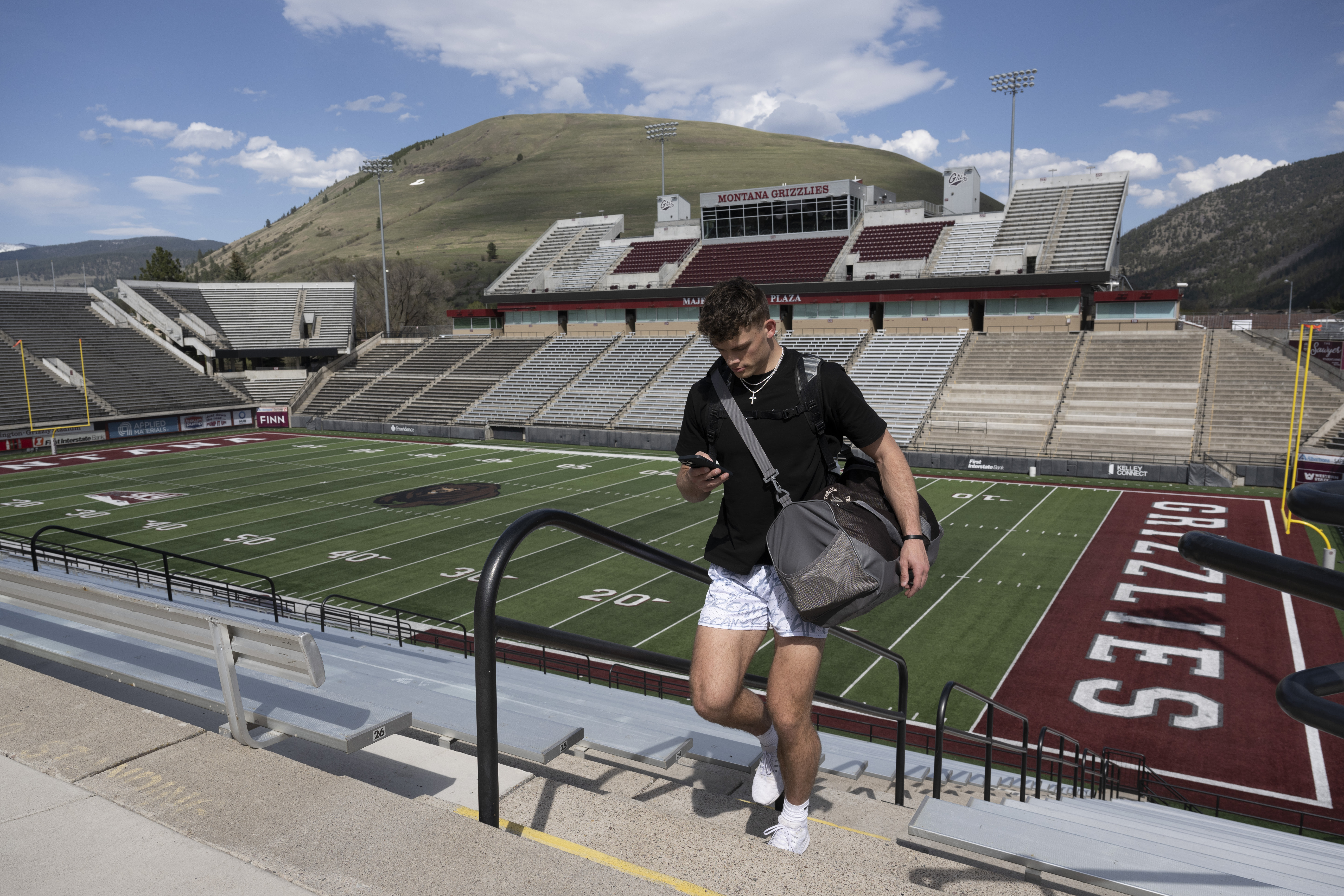 Adam Botkin, a football TikTok influencer, uses his phone after recording a video for a post at Washington-Grizzly Stadium in Missoula, Mont.