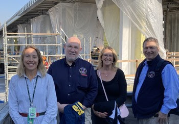 Four people posing for a photo at a construction site