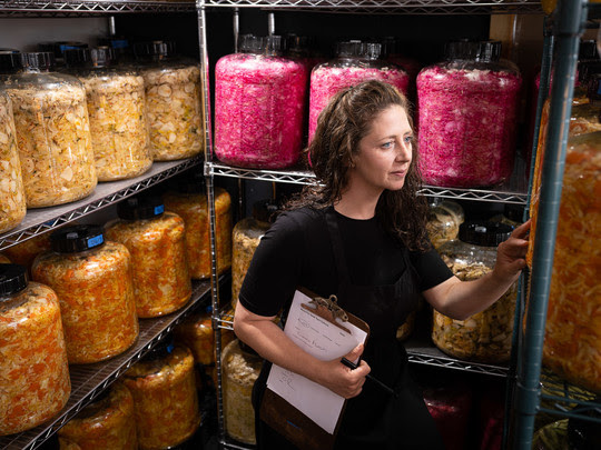 Photo of a woman with a clipboard checking ferments