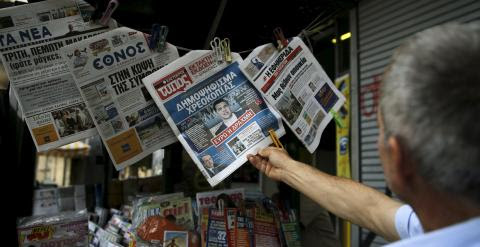 Un hombre lee en un quiosco en Atenas los periodicos del día con la noticia de la convocatoria del referendum sobre el rescate.  REUTERS/Alkis Konstantinidis