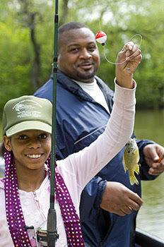 A young girl learns to fish for panfish at Palmer Park in Detroit.