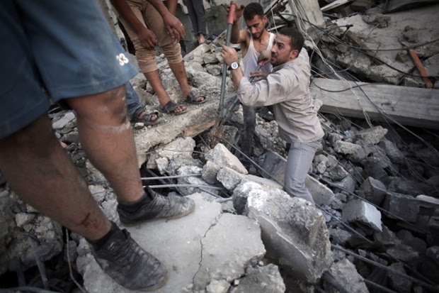 Palestinians search the rubble of a destroyed house where five members of the Ghannam family were killed in an Israeli missile strike early morning in Rafah refugee camp, southern Gaza Strip.