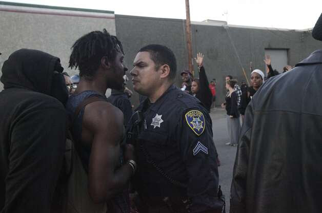 A police officer and a protester have a tense moment before a scuffle breaks out between a different protester and police officers near the port during an "F the Police" march held in solidarity with Ferguson, Mo., where there was a fatal shooting of an unarmed 18-year-old black man earlier in the week August 15, 2014 in Oakland, Calif. Photo: Leah Millis, The Chronicle