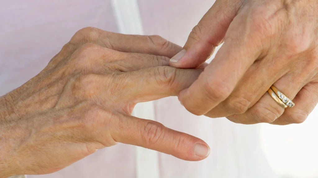 a woman holding her finger joint as she has pain there