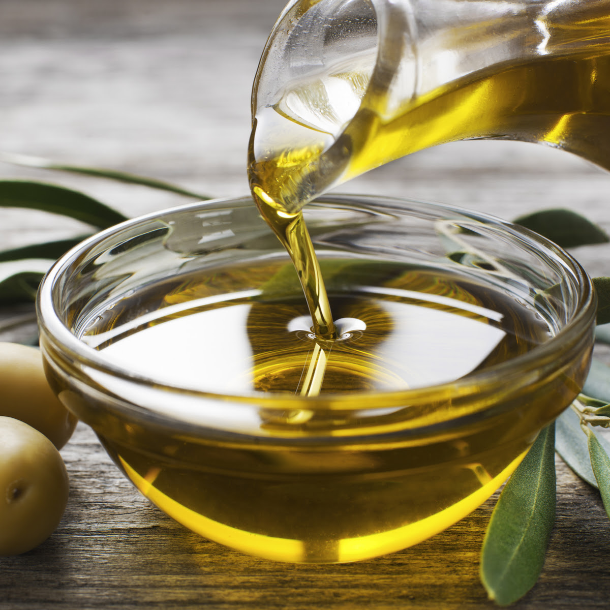 olive oil pouring into small glass bowl