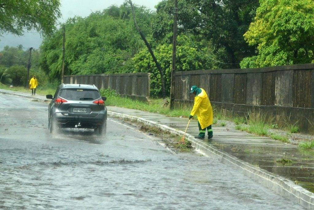 Funcionários da prefeitura de João Pessoa limpam bueiros para ajudar no escoamento da água durante período de chuvas intensas