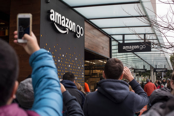 Shoppers and passers-by glimpsed the exterior of the Amazon Go grocery store during the location’s beta launch in Seattle in December.