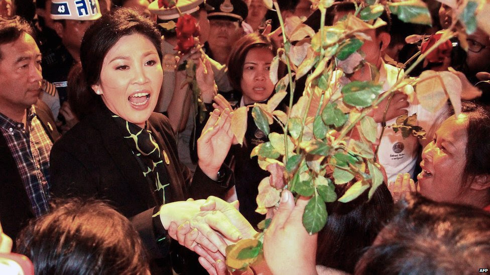  La primera ministra tailandés Yingluck Shinawatra (izquierda) recibe flores de sus partidarios al llegar al aeropuerto en la provincia de Chiang Mai, el 11 de diciembre 2013. AFP
