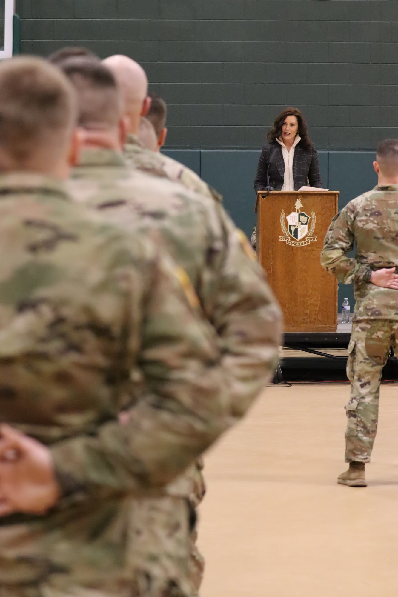 Gov. Whitmer speaks at podium during the deployment ceremony at Howell High School