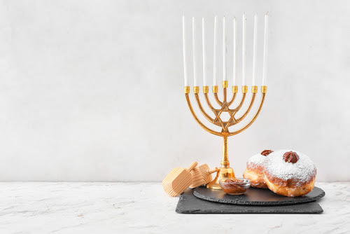 Menorah_ dreidels and donuts for Hanukkah on white background