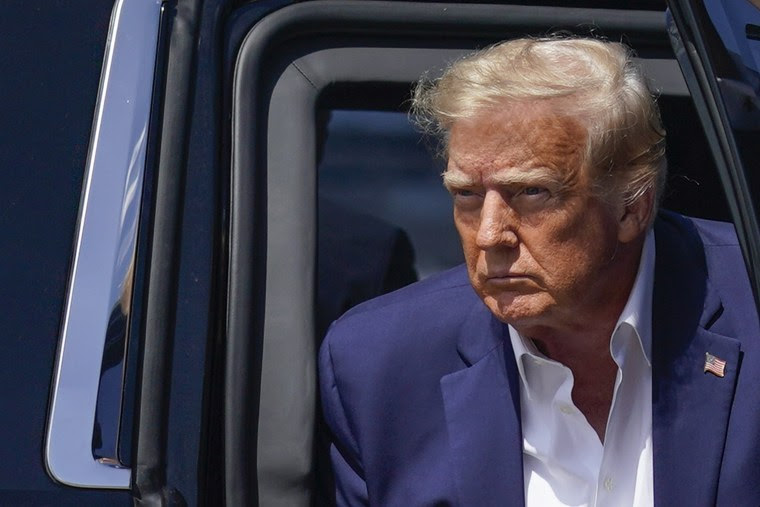 Former President Donald Trump arrives to board his airplane to a campaign rally in Waco, Texas, on March 25, 2023, in West Palm Beach, Fla.
