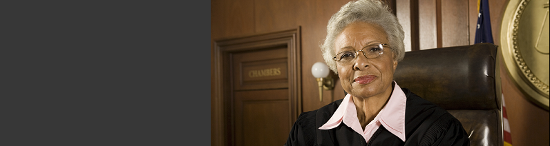 older female judge in judge's robe sitting in courtroom