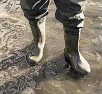 Person wearing boots in floodwater