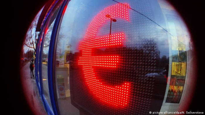 Sinal do euro refletindo em lente esférica Sinal do euro refletindo em lente esférica
