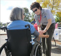Medical Reserve Corps volunteer talking to person in a wheelchair.
