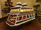 A Washington State Ferries vessel made out of gingerbread with plastic toy vehicles on the the car deck