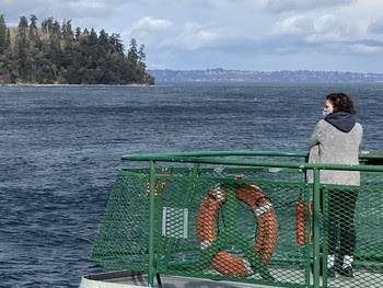 Photo of masked person on outdoor deck of ferry