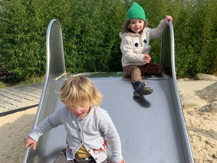 Barnaby Brownsell, two, is shown on a playground slide with his much smaller cousin who is the same age.