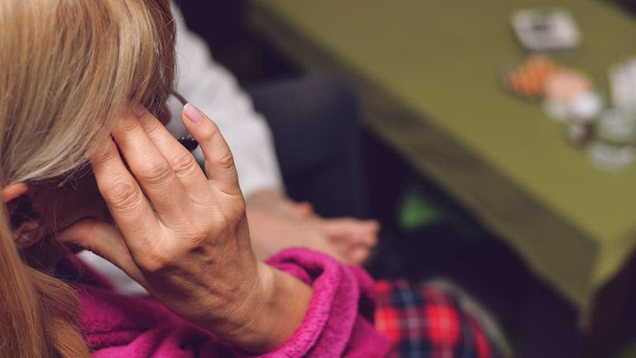 Overhead cropped shot of a woman rubbing her temple as she is trying to remember what medications to take.