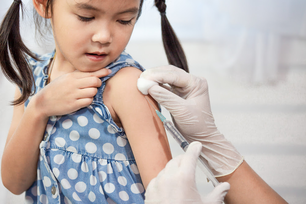 young asian girl getting an injection in her arm