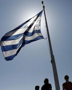 Un grupo de turistas junto a la bandera griega, en la Acrópolis de Atenas. REUTERS/Kostas Tsironis