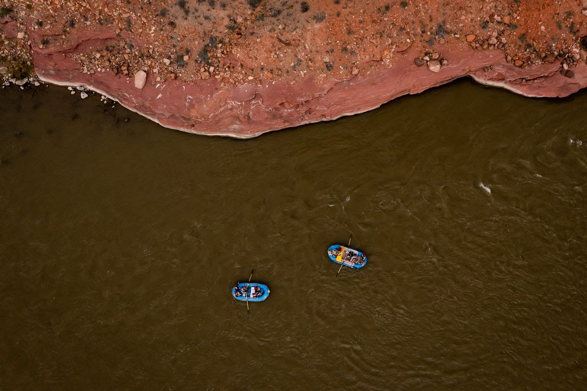 A raft carrying Sen. Mitt Romney, R-Utah, his wife, Ann, and Sen. Michael Bennet, D-Colo., right, floats down a section of the Colorado River northeast of Moab on Saturday, Sept. 18, 2021.