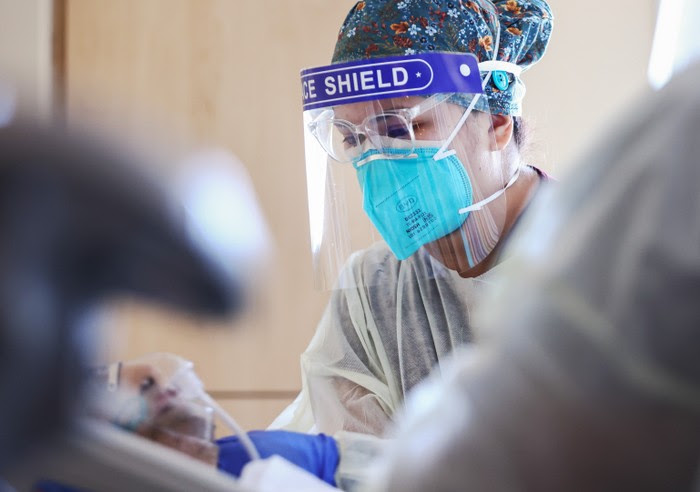 A nurse wearing a face mask and face shield