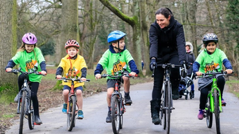 Children cycling along path with female instructor