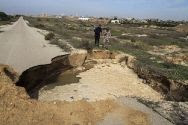 Palestinian Authority security personnel stand next to a landslide made by the seawater pumped into the area by the Egyptian army to flood Hamas tunnels near the border between Egypt and southern Gaza near Rafah. (file)