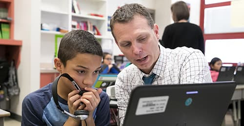 David Floyd looking at a laptop with a male student.