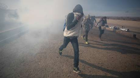 Migrantes huyen del gas lacrimógeno lanzado por los agentes fronterizos estadounidenses cerca de la valla entre México y EE.UU., Tijuana 25 de noviembre de 2018.