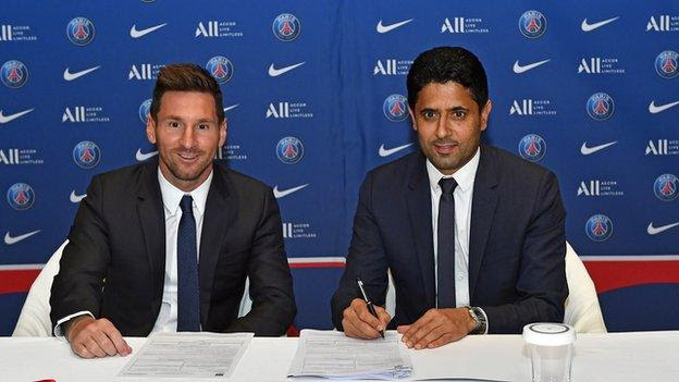 Lionel Messi signing his PSG contract with club president Nasser al-Khelaifi