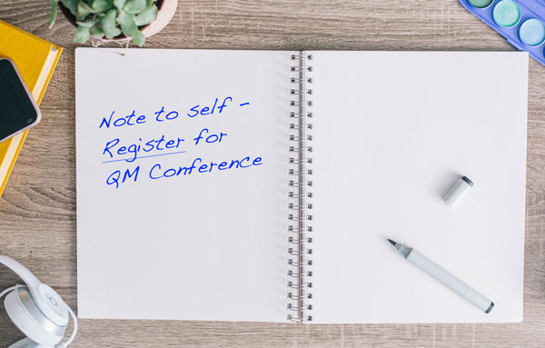 notebook with note to self: register for QM conference written in it
