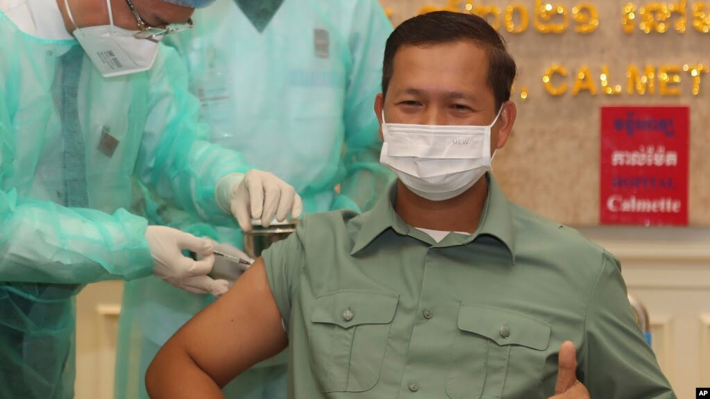 FILE - Cambodia's Lt. Gen. Hun Manet, a son of Prime Minister Hun Sen, thumbs up as he receives a shot of the COVID-19 vaccine at Calmette hospital in Phnom Penh, Cambodia, Wednesday, Feb. 10, 2021. (AP Photo/Heng Sinith)