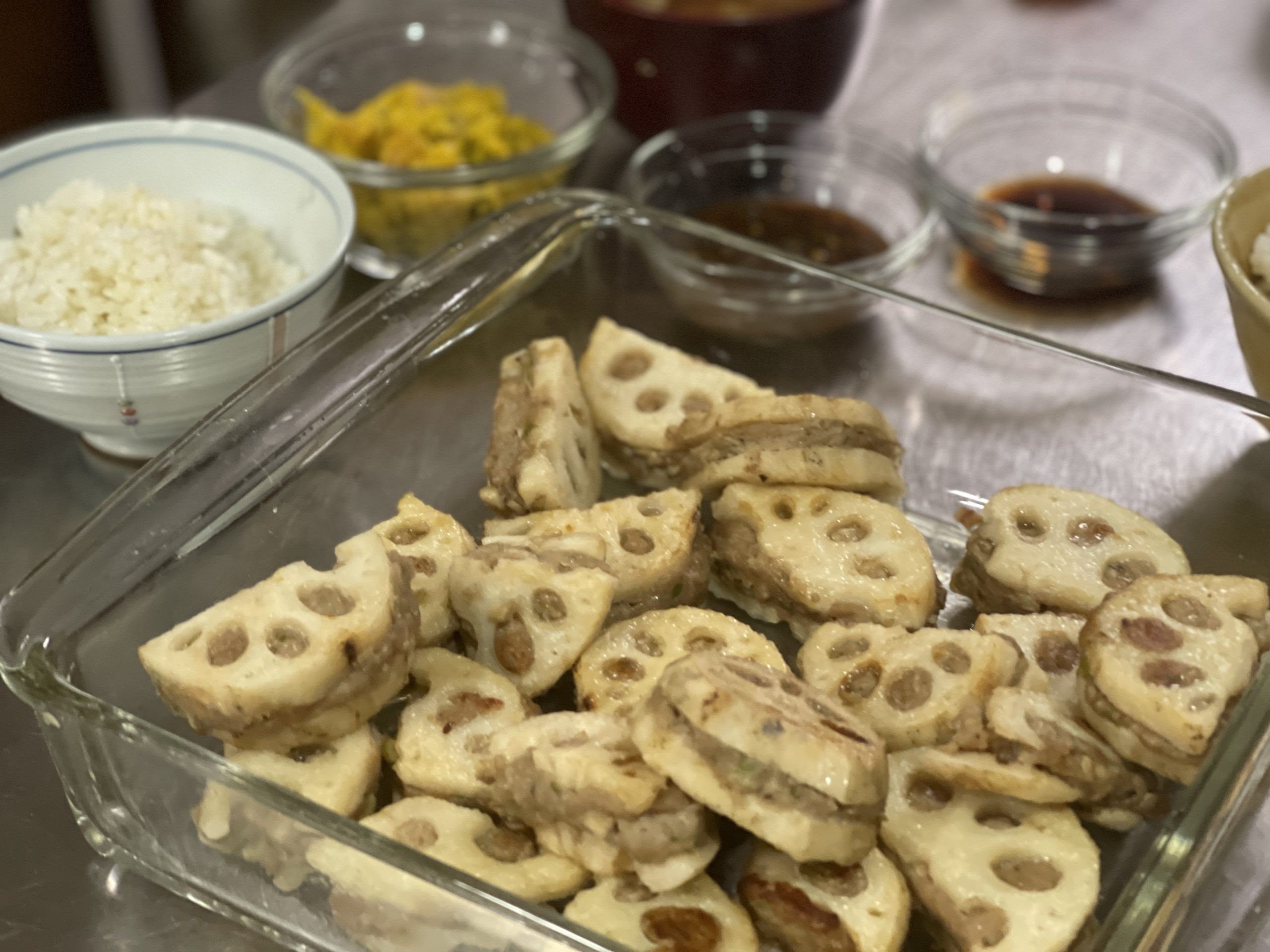 蓮根の挽肉挟み焼きがガラスの器に入っている食卓