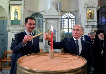 Russian and Syrian Presidents Vladimir Putin and Bashar Assad light candles while visiting an orthodox cathedral for Christmas, in Damascus, January 7, 2020