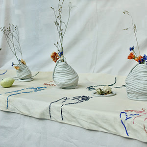 A photograph of a window display with bases and flowers.