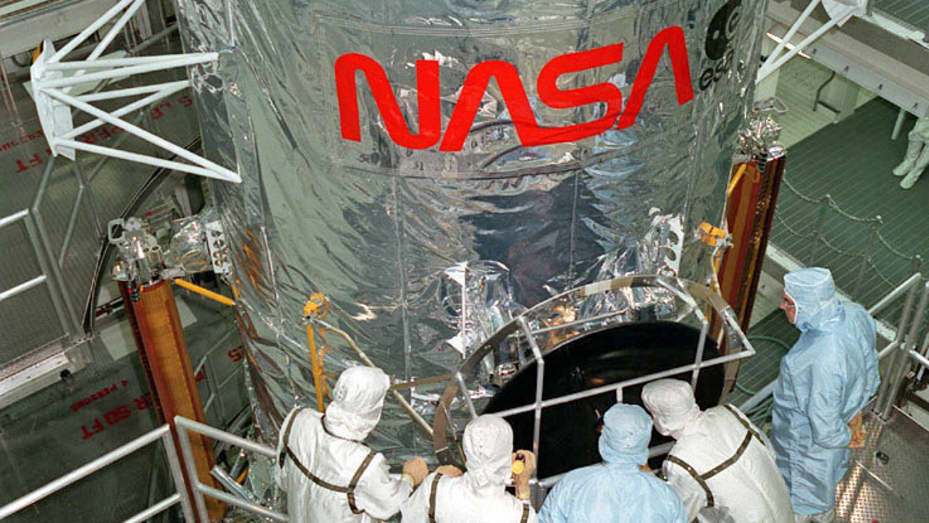 Lockheed Martin technicians examine part of NASA's Hubble Space Telescope during assembly.