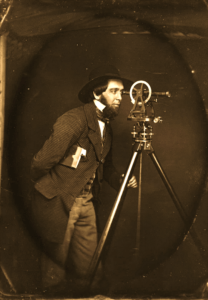 George Y. Wellington, at his theodolite with his surveyor’s field book tucked beneath his arm. Circa 1850 studio daguerreotype.